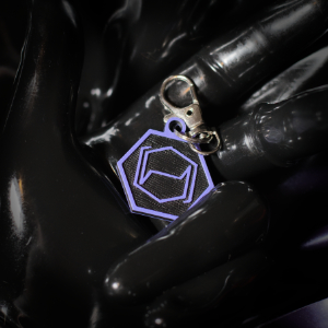 A Hexcorp keychain in a rubber gloved hand